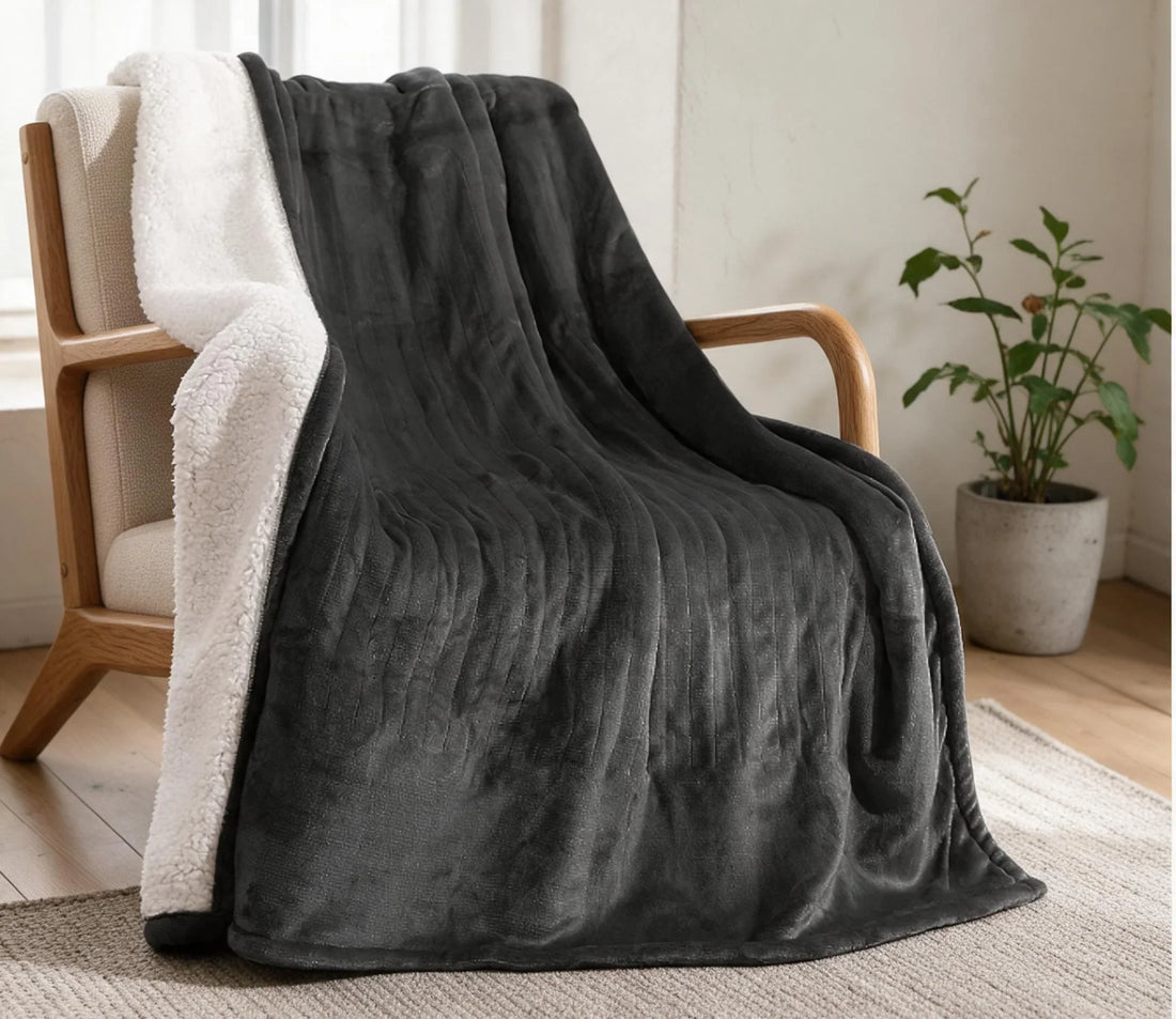 Warmhold Sherpa Heated Blanket in Dark Gray draped over an armchair